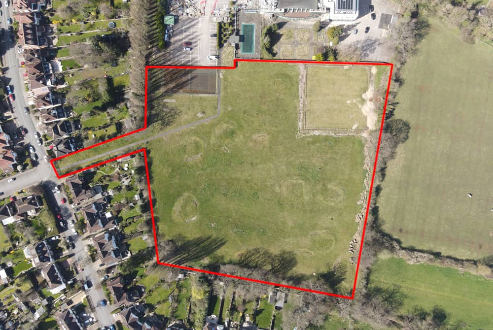 Aerial view of a development site outlined with a red boundary, illustrating how site boundary decisions impact Biodiversity Net Gain (BNG) calculations.