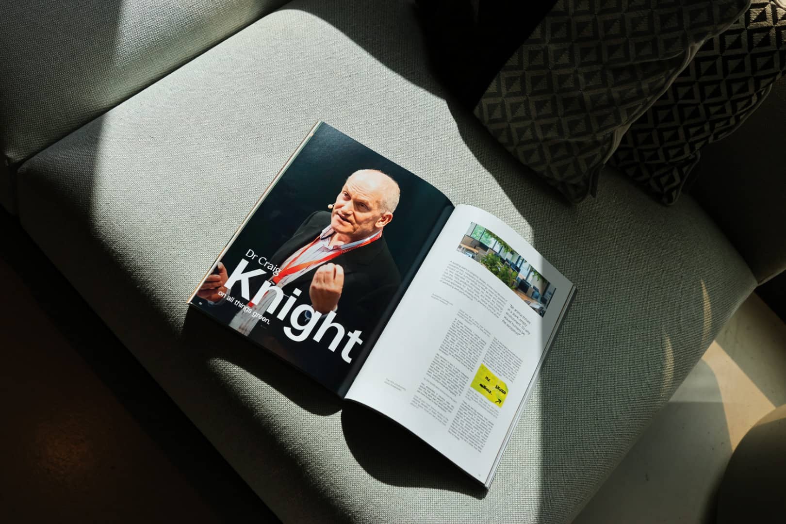 Open magazine on a sofa, featuring a man labeled as Dr. Craig Knight, with articles and images about green topics visible.