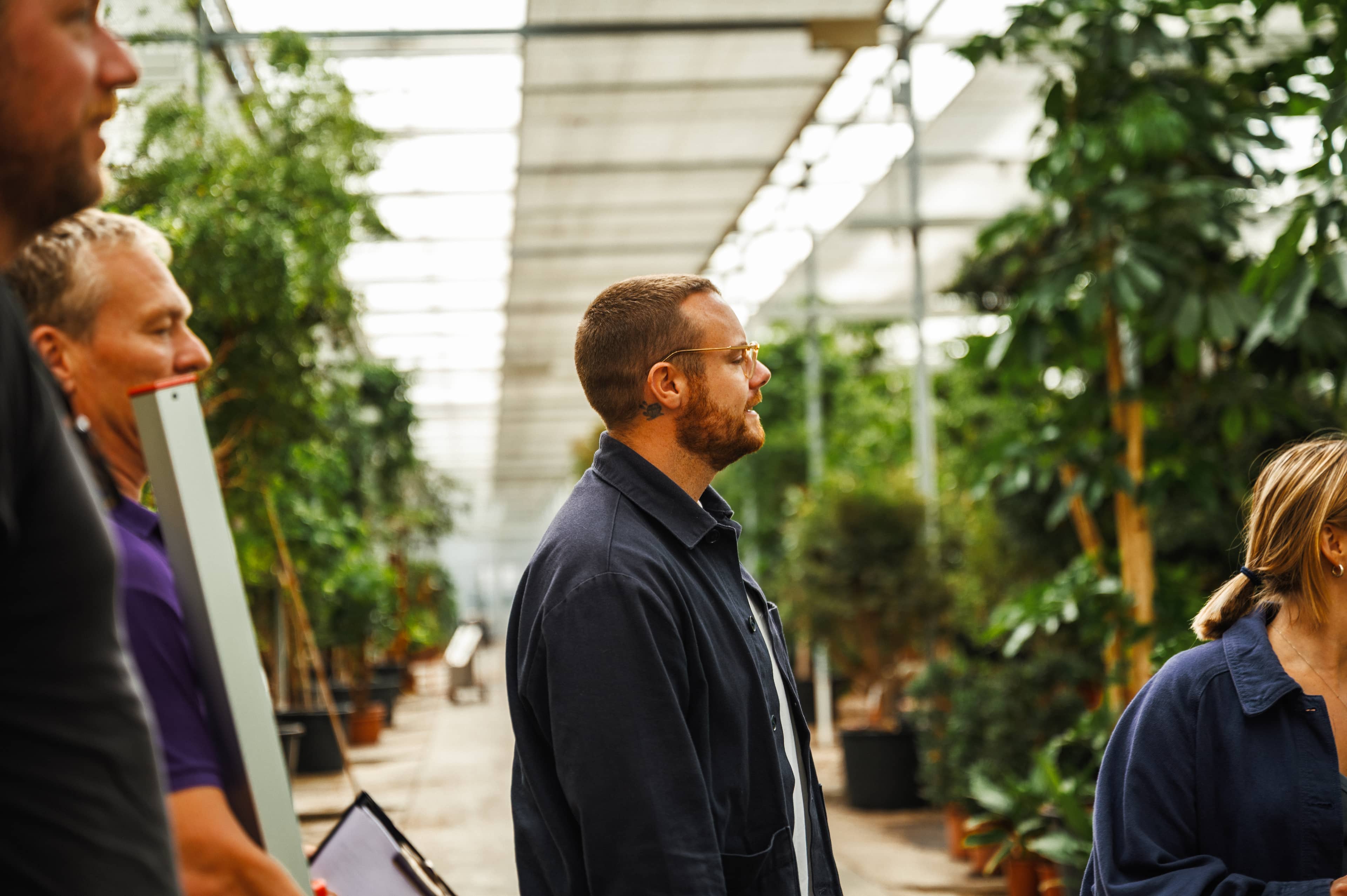 A man in the foreground surrounded by green trees