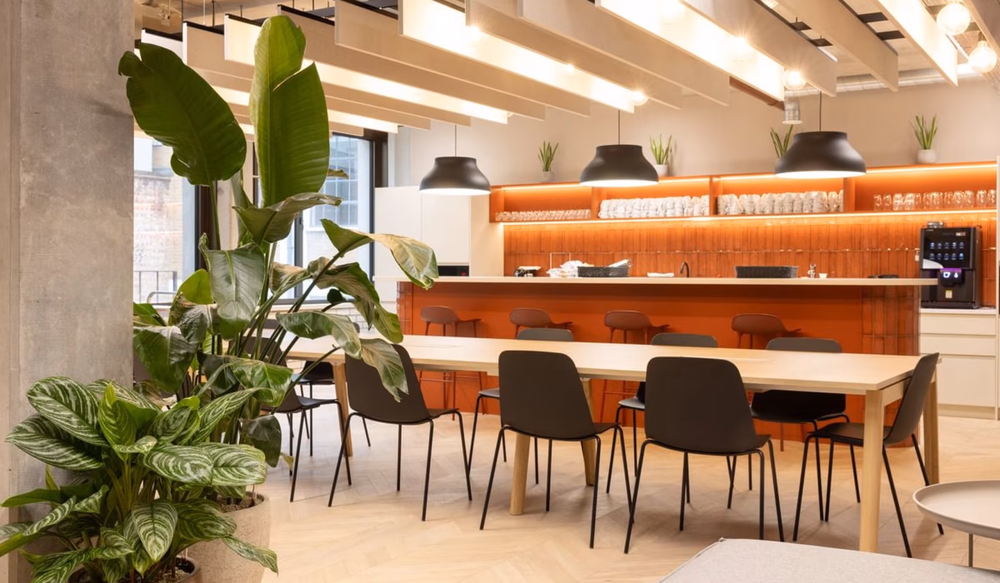 Communal workplace canteen with tall standing plants in the foreground